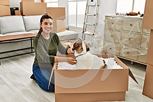 Young woman smiling confident playing with dog at home