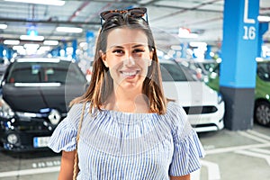 Young woman smiling confident at underground parking lot around cars and lights