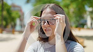 Young woman smiling confident wearing glasses at park