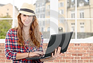 Young woman with smiling face holding laptop