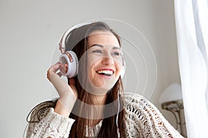 Young woman smiling and listening to music with headphones