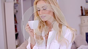 Young woman smiling in pleasure enjoying coffee