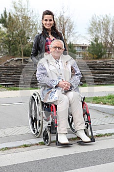 Young woman smiling with senior woman in wheelchai