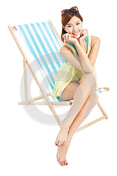 Young woman smiling and sitting on a beach chair