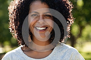 Young woman smiling while standing in a park in summer