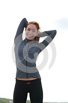 Young woman smiling and stretching muscles before workout