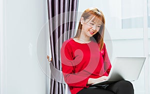 Young woman smiling, student girl sitting on chair during working with laptop computer at home office