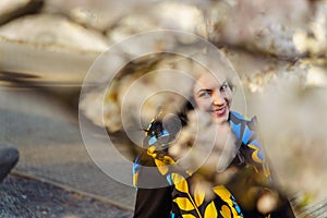 Young woman smiling while walking in blooming cherry blossom garden in spring