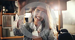 Smiling young woman standing on a bus listening to music