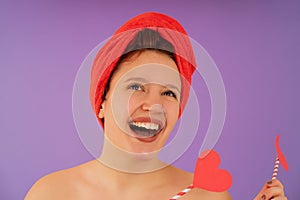 Young woman smiling while wearing a towel on her head.