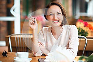 Young woman smokes tobacco in a cafe