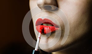 Young woman with smooth skin applying liquid red lipstick