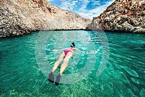 Young woman snorkeling in clear tropical water. Traveling, active lifestyle concept. Watersports on vacation