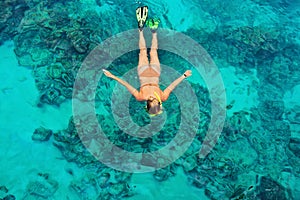 Young woman snorkeling with coral reef fishes