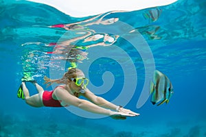 Young woman in snorkeling mask dive underwater with tropical fishes
