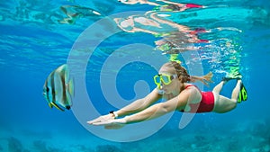 Young woman in snorkeling mask dive underwater with tropical fishes