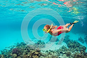 Young woman in snorkeling mask dive underwater with tropical fishes photo