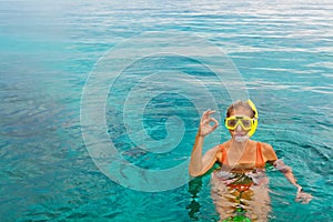 Young woman in snorkeling mask showing divers sign OK