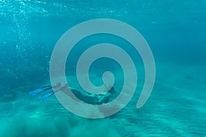 Young woman snorkeling over coral reef in the tropical sea.