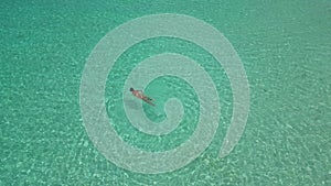 Young woman at snorkeling in the tropical water n Maldives aerial view