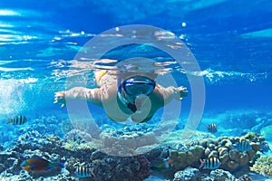 Young woman snorkels in tropical water of Thailand photo