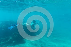 Young woman snorkling under water sea reef and coral. Summer vocation.