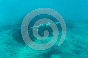 Young woman snorkling under water sea reef and coral. Summer vocation.