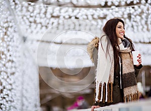 Young woman in a snow park drinks tea