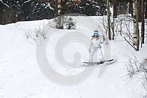 Young woman snowboarder in motion on snowboard in mountains