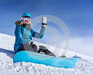 Young woman snowboarder in mountains