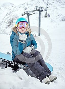 Young woman snowboarder in mountains