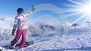 Young woman snowboarder in mountains