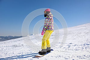 Young woman snowboarding on hill