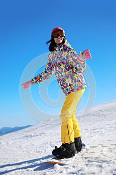 Young woman snowboarding on hill. Winter