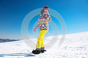 Young woman snowboarding on hill. Winter