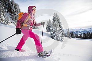 Young woman snowshoeing in high mountains