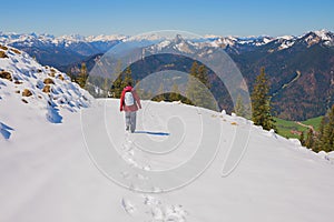 Young woman at snowy wallberg mountain, hiking trail down, early springtime