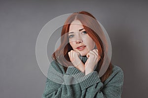 young woman snuggling into warm turtleneck sweater