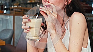 Young woman socializing in cafeteria drinking coffee alone