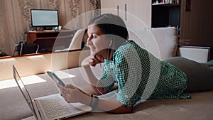 Young woman on sofa happily working on new project with laptop in home