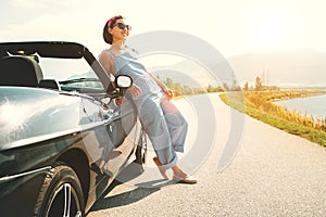 Young woman solo traveler stay near cabriolet car on picturesque