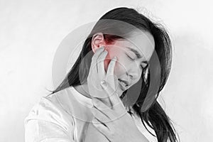 Young woman with sore ear, suffering from otitis, black and white panorama with red accent, free space