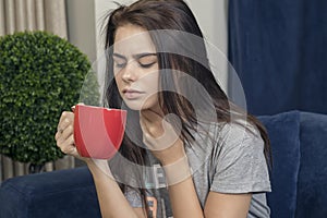 Young woman with a sore throat drinking tea