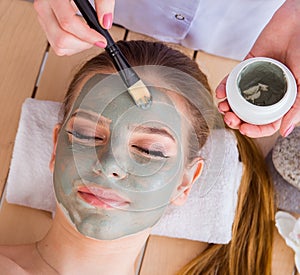 Young woman in spa health concept with face mask