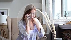 Young woman speaking mobile phone at home, beautiful girl flirting on phone.