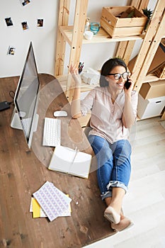 Young Woman Speaking by Phone at Desk