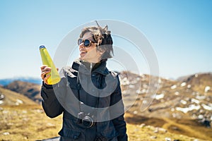 Young woman spending free time in national park/mountains.Hiking outdoor experience.Drinking from reusable vacuum insulated water