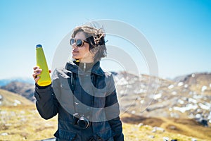 Young woman spending free time in national park/mountains.Hiking outdoor experience.Drinking from reusable vacuum insulated water