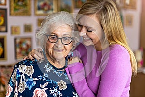 Young woman spending time with her elderly grandmother at home