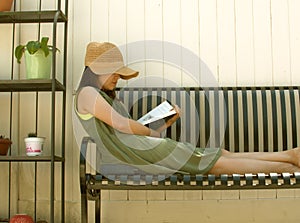 Young Woman Spending Time at Home Self Isolation Reading a Book in Back yard Gardening